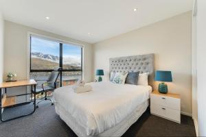 皇后镇Queenstown Lake and Mountain View Retreat Free Wifi Free Street Parking的一间卧室配有一张床、一张书桌和一个窗户。