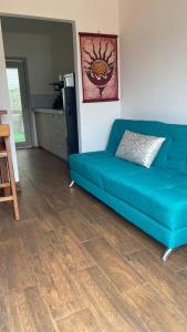 洛佩斯港Verano Azul Loft的客厅铺有木地板,配有蓝色沙发。