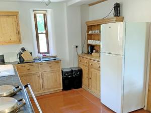 TolpuddleNorth Barn的厨房配有白色冰箱和木制橱柜。