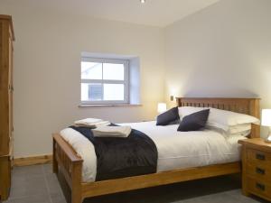 LlanglydwenStambar的一间卧室配有一张带白色床单的床和一扇窗户。