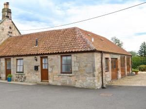 林利斯戈The Cottage At Cauldcoats的一座红色屋顶的古老石头建筑