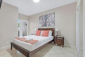 赫斯基森杰维斯湾景色别墅的一间卧室配有一张带橙色枕头的大床