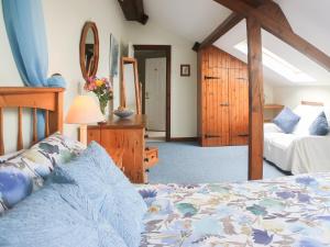 库姆马丁林地景度假屋的一间卧室配有一张床和镜子