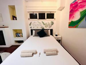 埃斯托利尔Estoril Seaside Guest House的卧室配有一张带两个枕头的大白色床