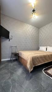 乌拉尔斯克гостинично-ресторанный комплекс AMARI的一间卧室配有一张大床和一把椅子