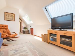 怀伊Mitford Lodge的客厅配有平面电视和椅子。
