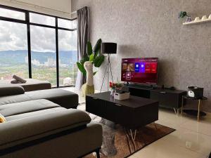 乔治市Beacon Executive Suite by stayCATion Homestay的客厅配有电视、沙发和桌子