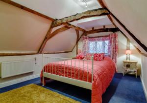 MetfieldStreet Farm-Metfield的阁楼卧室配有红色床