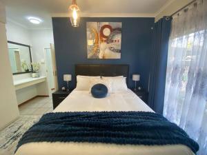 逊邱伦CozyatCaley - Private Apartment的一间卧室设有一张蓝色墙壁的大床