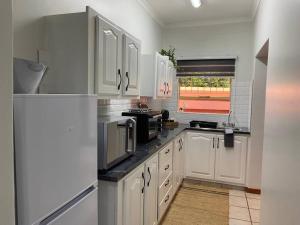 逊邱伦CozyatCaley - Private Apartment的厨房配有白色橱柜和白色冰箱。