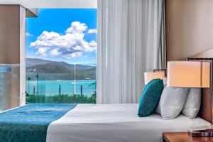 埃尔利海滩圣灵群岛梦幻度假村的一间卧室设有一张床和一个大窗户