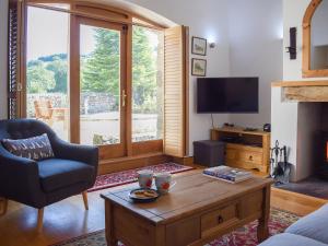 TalleyBarn Cottage的带沙发、桌子和电视的客厅