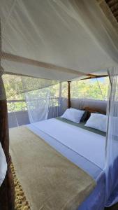 MkwajaMahali Maalum Barefoot Lodge的帐篷内一间卧室,配有一张大床