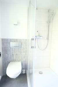埃森Hotel Das Lola的带淋浴和卫生间的白色浴室