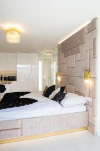 特尔斯泰纳Penthouse apartments MINI s privátnou vírivou vaňou的卧室配有一张白色大床和石墙