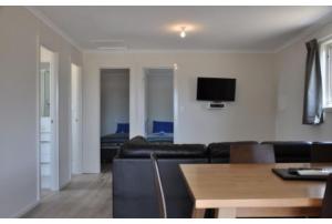 弗林德斯彻斯Discovery Parks - Kangaroo Island的客厅配有沙发和墙上的电视