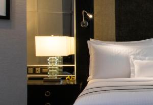 吉隆坡The Ritz-Carlton, Kuala Lumpur的一间卧室,配有一张床和床头灯