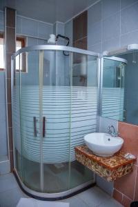 ThikaThe Luke Hotel Cravers Thika的一间带玻璃淋浴和水槽的浴室