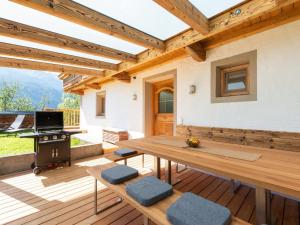 Dorfbeautifully renovated farmhouse Stoanerbauer with a wonderful view的木制庭院设有桌子和烧烤架