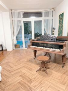 基特塞4 room flat with garden and pool的客厅里的钢琴和凳子