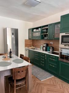 基特塞4 room flat with garden and pool的厨房配有绿色橱柜和桌椅