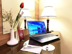 吉达罗山艾尔阿扎酒店的一张桌子上的笔记本电脑,上面放着两盏灯
