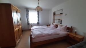 诺伊舍瑙Bauernhof Madlhof的一间卧室配有一张带白色床单的床和一扇窗户。