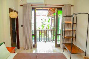希克杜沃IBSON Villa - 02 Hikkaduwa with 4 Bedrooms & Salt Water Swimming Pool的一间卧室设有一张床,并有通往阳台的门