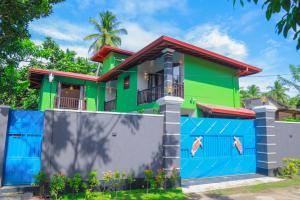 希克杜沃IBSON Villa - 02 Hikkaduwa with 4 Bedrooms & Salt Water Swimming Pool的色彩缤纷的房屋,设有围栏