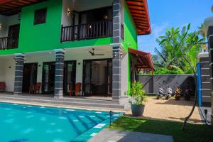 希克杜沃IBSON Villa - 02 Hikkaduwa with 4 Bedrooms & Salt Water Swimming Pool的一座房子前面设有游泳池