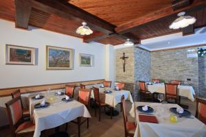费德拉帕加内拉Hotel Stella Alpina的一间设有白色桌椅的餐厅,拥有砖墙