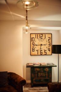维也纳Hotel Calmo的客厅配有沙发和墙上的时钟