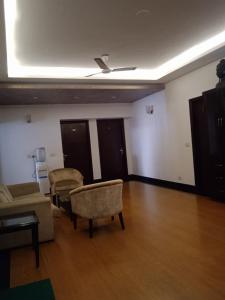诺伊达Tavisha Villa Flim City Road Dadri Road的带沙发和椅子的客厅以及天花板