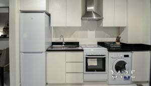 迪拜Rare Holiday Homes - Spacious apartment - Near Expo City - Dubai South - R410的白色的厨房配有炉灶和水槽