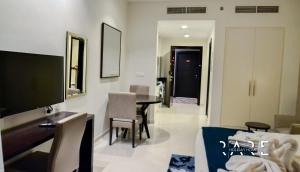 迪拜Rare Holiday Homes - Spacious apartment - Near Expo City - Dubai South - R410的客厅配有电视和桌椅