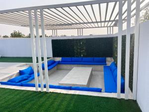 乌姆盖万Falaj Hub Retreat的凉亭,庭院里设有蓝色沙发