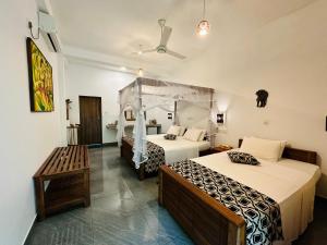 达瓦拉维自然之家旅馆的酒店客房带两张床和长凳