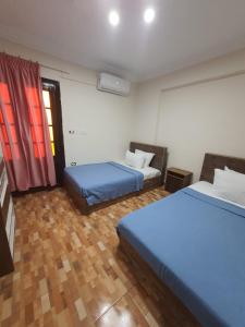 亚历山大Saraya Eltram-families only的客房设有两张床和窗户。