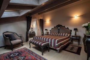 法布里亚诺塞拉米卡酒店的一间卧室配有一张大床和一把椅子