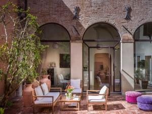 法布里亚诺塞拉米卡酒店的一座带桌椅的庭院和一座砖砌建筑
