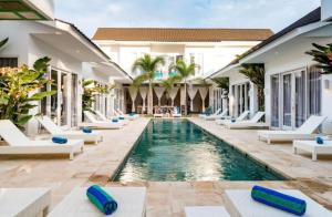吉利特拉旺安Cocotoa Boutique Hotel & Villa的度假村中心带躺椅的游泳池