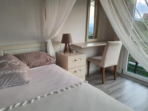卡特佩Villa Mila的卧室配有床、椅子和窗户。