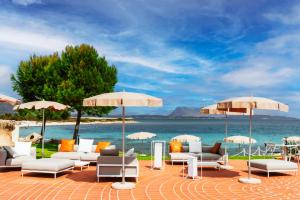 圣特奥多罗AMASEA Resort的海滩上的一组椅子和遮阳伞