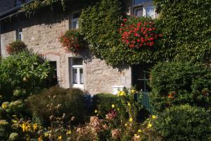亚琛乌拉与威利乡村公寓的一座石头房子前面有鲜花