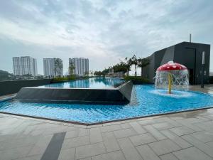 加影1 Room Studio @ MKH Boulevard 2的一个带遮阳伞和喷泉的游泳池