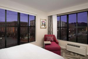 亨茨维尔阿拉巴马州普罗维登斯村亨茨维尔汉普顿酒店的卧室设有红色椅子和大窗户