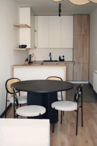 克罗托申Apartamenty Centrum的厨房配有桌椅和水槽。