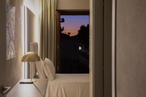 布雷西亚Hotel Battisti 31的客房设有一张床,享有窗户的景色