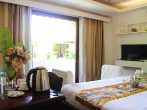 爱妮岛里奥别墅度假酒店的酒店客房设有床、桌子和窗户。