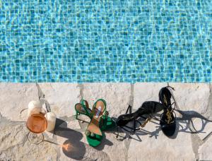 泽斯特拉格Holiday home Blue Sky的游泳池旁的一双鞋和一双眼镜